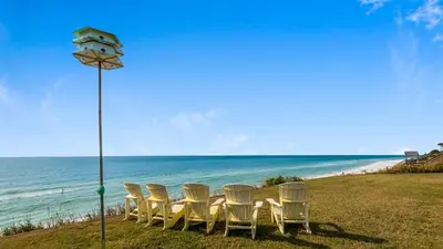 a group of chairs and a table on the beach at Sand Cliffs 106 in Seacrest