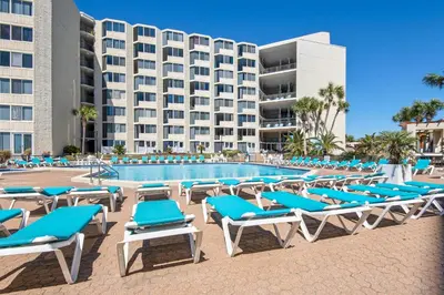 a pool with lounge chairs and a hotel at Top of the Gulf 324 in Panama City Beach