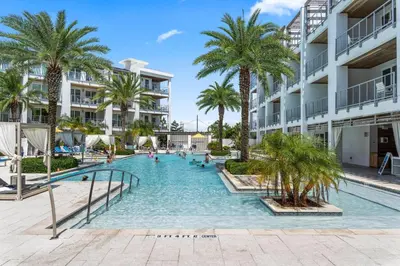 a swimming pool in the middle of a resort with palm trees at The Pointe on 30A by Panhandle Getaways in Rosemary Beach