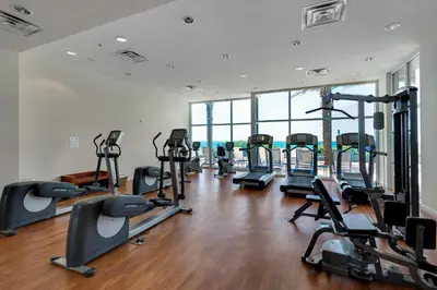 a gym with treadmills and ellipticals in a building at Sterling Breeze 1204 in Panama City Beach