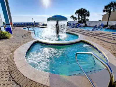 a swimming pool with a fountain in a resort at Majestic Beach Towers I #1015 in Panama City Beach