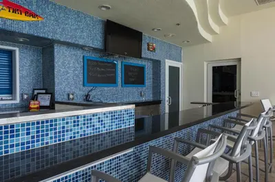 a restaurant with a bar with blue tiles at Sterling Breeze 804 in Panama City Beach