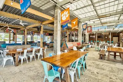 an empty restaurant with wooden tables and chairs at Totally Beachin' in Inlet Beach