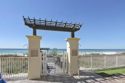 a gate at the beach with the ocean in the background at Shores of Panama 2217- Elegantly Decorated, Sleeps 6, Free Fun! condo in Panama City Beach