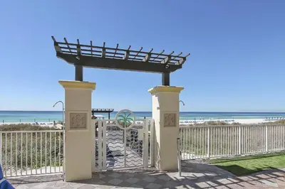 a gate at the beach with the ocean in the background at Shores of Panama 1206 - Amazing Studio, Free Fun! Sleeps 3, Romantic condo in Panama City Beach