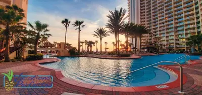 a large swimming pool with palm trees and buildings at Shores of Panama 401 - 4th Floor 3 Bedroom 3 Bath Sleeps 8, Same Floor Resv, Parking! Updated! condo in Panama City Beach