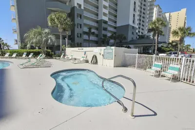 a hot tub in a pool with chairs and buildings at Long Beach Tower 3, #1303 - Completely Renovated 2 Bedroom Sleeps 8, condo in Panama City Beach