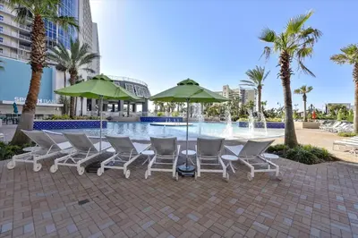 a group of chairs and umbrellas next to a pool at Laketown Wharf 1003, Gulf View, Sleeps 6, Free Fun! Updated! condo in Panama City Beach