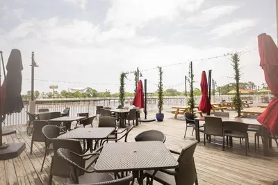 a patio with tables and chairs on a deck at Living Right at Laketown Wharf #1016 by Nautical Properties in Panama City Beach