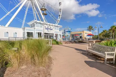 a large ferris wheel in a park with a bench at Water Park On-Site! 2 Beachfront Master Suites! Corner Balcony Views! in Panama City Beach