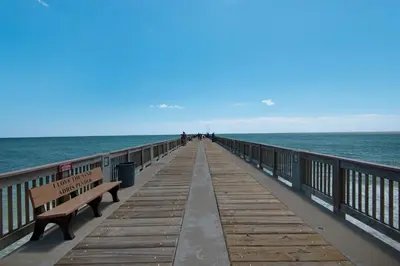 a wooden pier with benches and the ocean at CORNER UNIT! Beach Views! FREE WIFI! 3-Bed, 3-Bath! Sleeps 9! in Panama City Beach