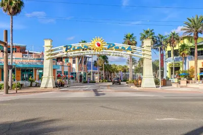 a city street with a carnival arch with palm trees at NEW PROPERTY! Vacation Right on the Gulf in Sand & Seafoam Villa Sleeps 6! in Panama City Beach