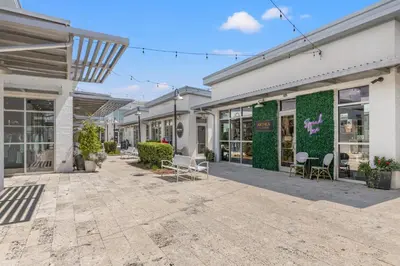 a group of buildings with chairs and plants at 24 York Lane | Edgewater Escape in Inlet Beach