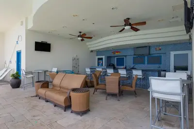 a dining room with tables and chairs and ceiling fans at Sterling Breeze 1105 in Panama City Beach