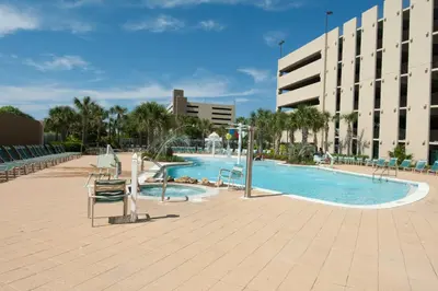 a large swimming pool with chairs and a building at Emerald Beach Resort by Blue Swell in Panama City Beach