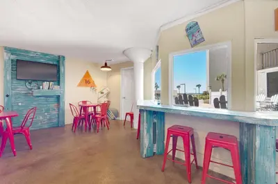 a room with a bar with red stools at Top of the Gulf 811 in Panama City Beach