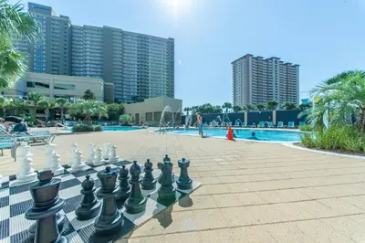 a giant chessboard in front of a pool with buildings at Emerald Beach 1036 - Turquoise Turtle in Panama City Beach