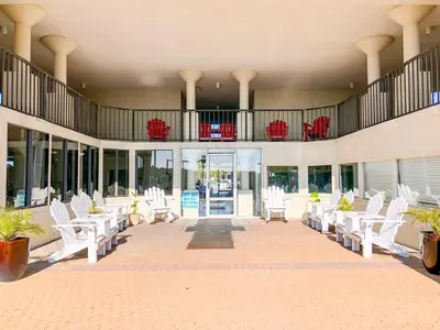 a lobby with white chairs and a balcony at Top of The Gulf 306 in Panama City Beach