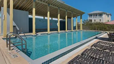 a large swimming pool with chairs next to a building at Bless My Sol in Santa Rosa Beach