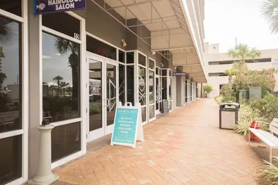a building with a sign in the middle of a sidewalk at A Shore Thing at Laketown Wharf #1904 by Nautical Properties in Panama City Beach