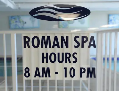 a sign that reads roman spam hours am pm at Tidewater 2613 in Panama City Beach