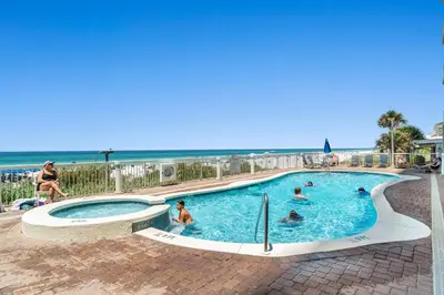 a swimming pool with people in it next to the beach at Seychelles #1007 in Panama City Beach