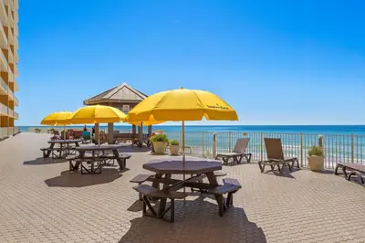 a group of tables and chairs with umbrellas on the beach at Treasure Island #1506 in Panama City Beach