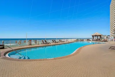 a swimming pool with the beach in the background at Treasure Island #0110 in Panama City Beach